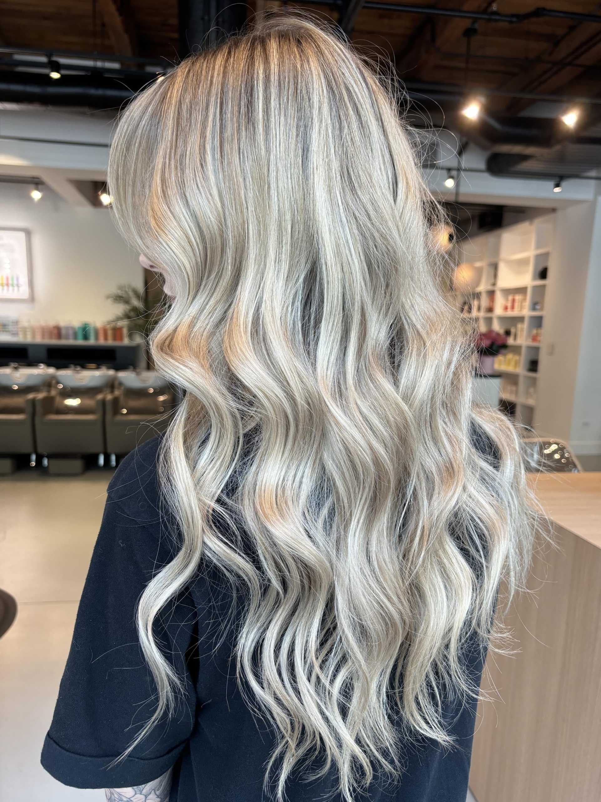 Long, wavy blonde hair in salon setting, showcasing a professional hairstyle.